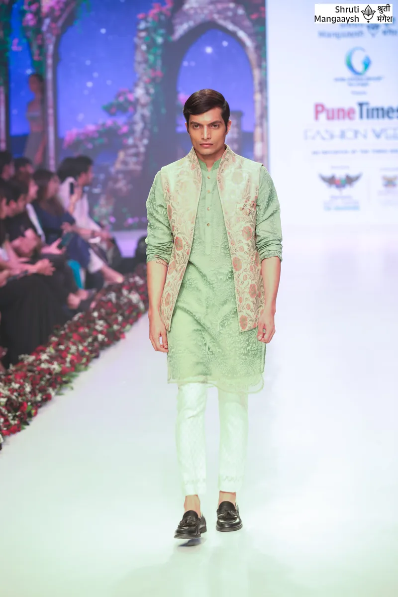 Model walking in a pale green kurta and matching trousers