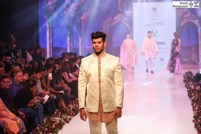 Model in an ivory jacket at the front of the runway