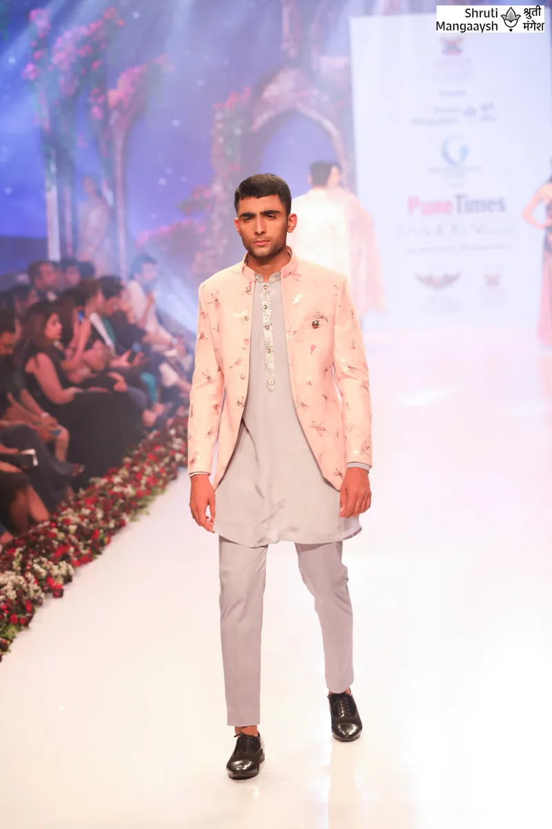 Model wearing a peach jacket over a grey kurta and trousers