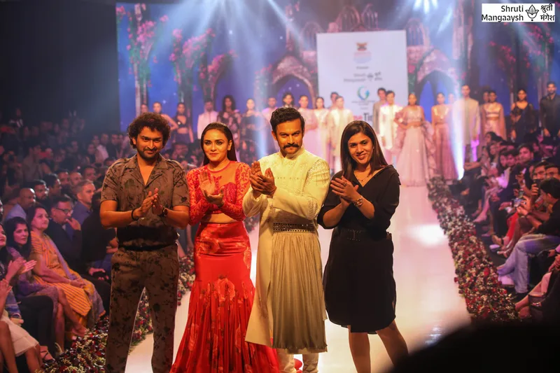 Runway finale with models in red, ivory and yellow outfits