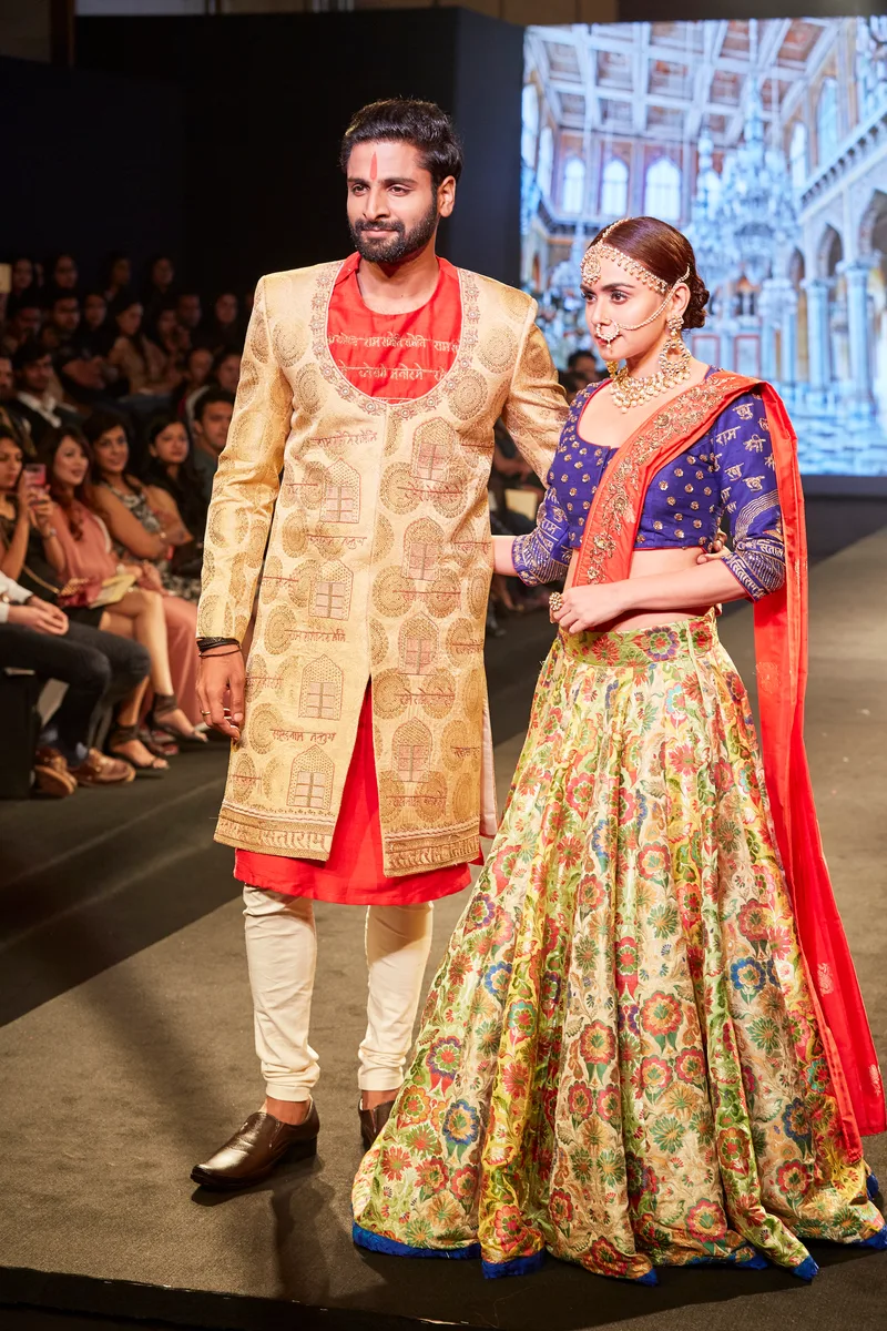 Gold sherwani and floral lehenga with red and blue details