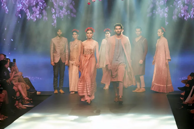 Runway finale with models wearing peach, ivory and taupe outfits