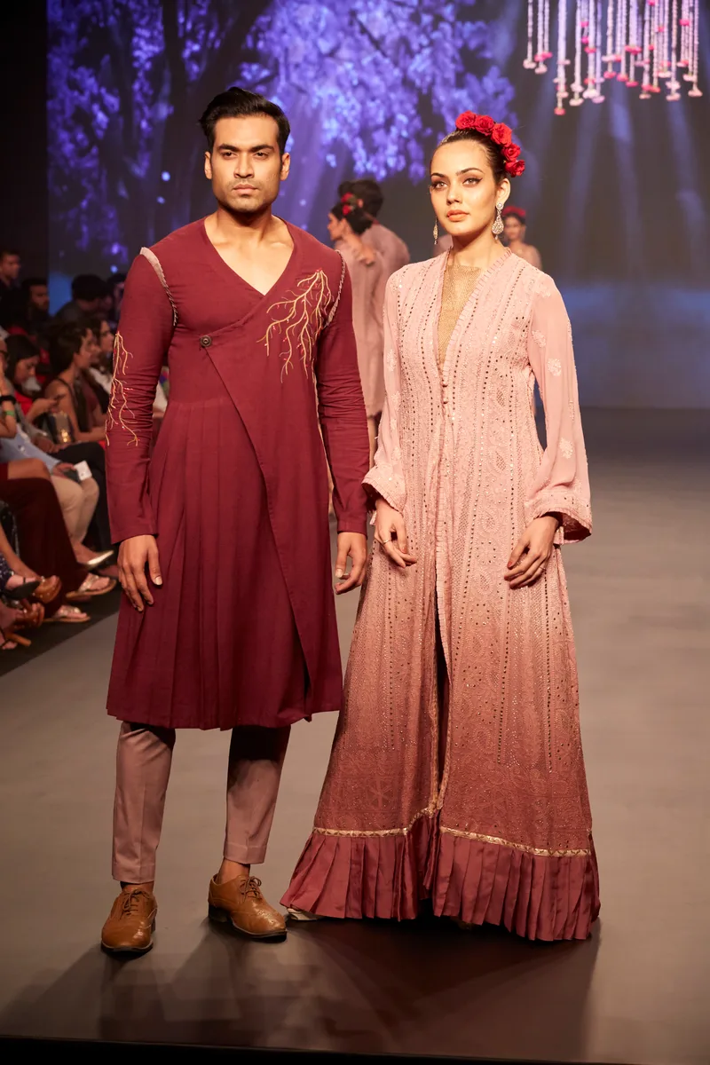Two models wearing a burgundy kurta and a pink embroidered outfit