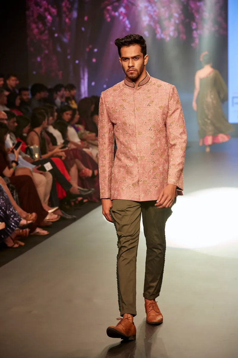 Model wearing a textured peach jacket with dark trousers