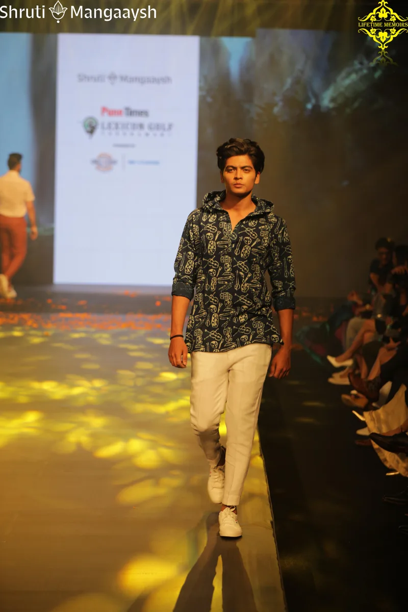 Model wearing a dark floral shirt and ivory trousers
