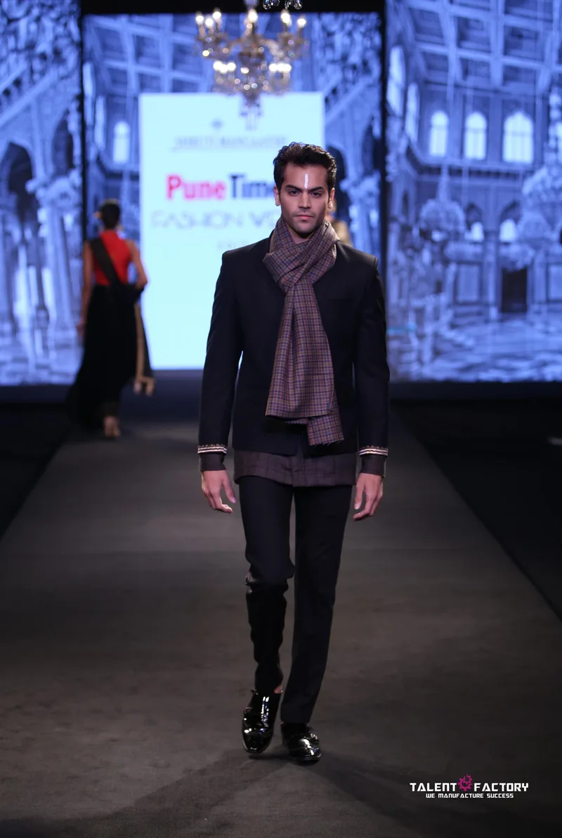 Model wearing a dark jacket over a mauve shirt
