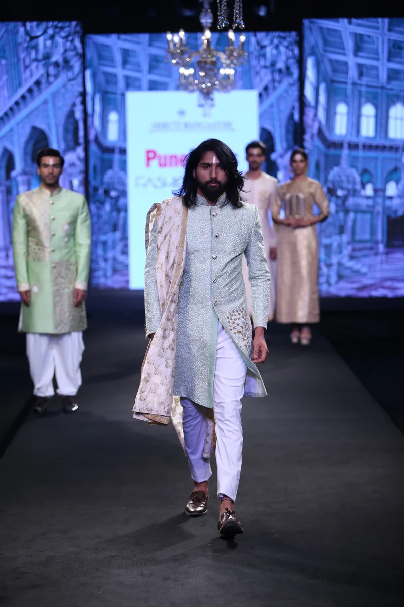 Model wearing an ivory embroidered coat over a pale kurta