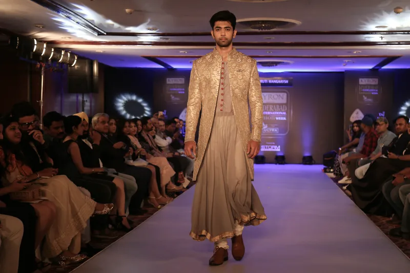 Model walking in a gold kurta and matching trousers