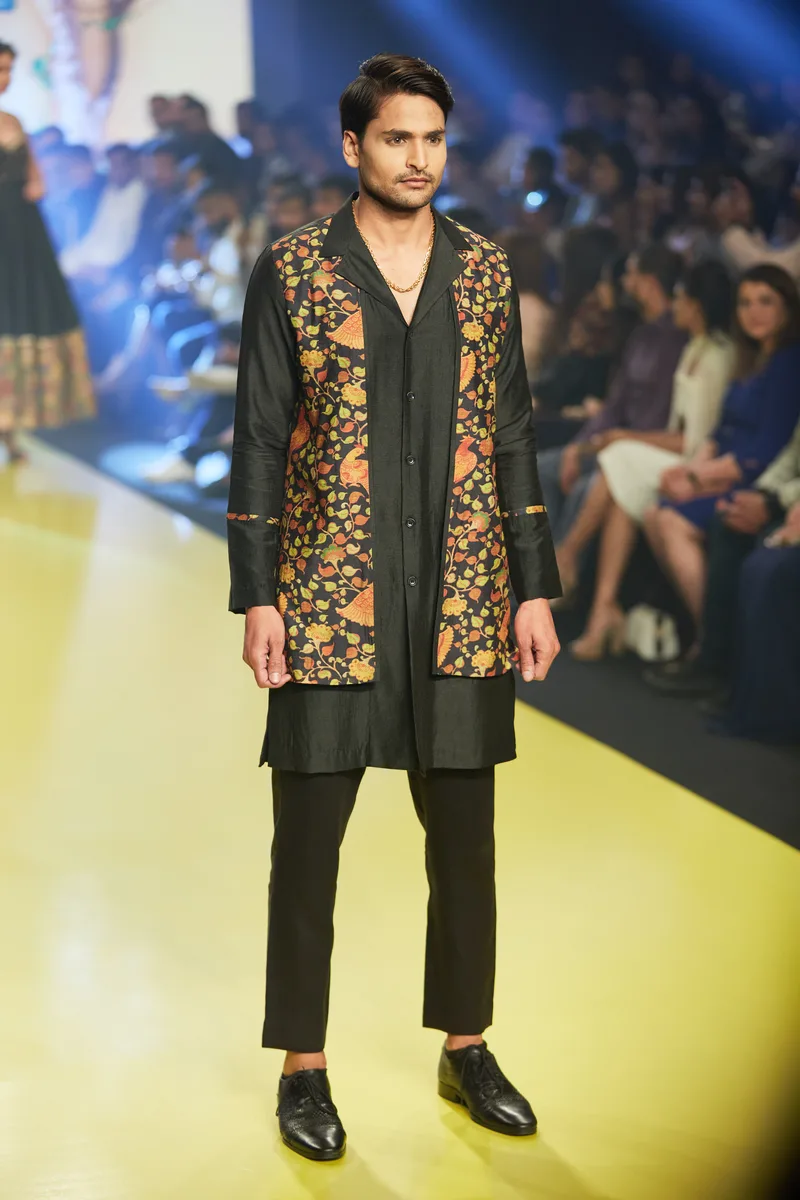 Model wearing a black jacket with gold floral embroidery