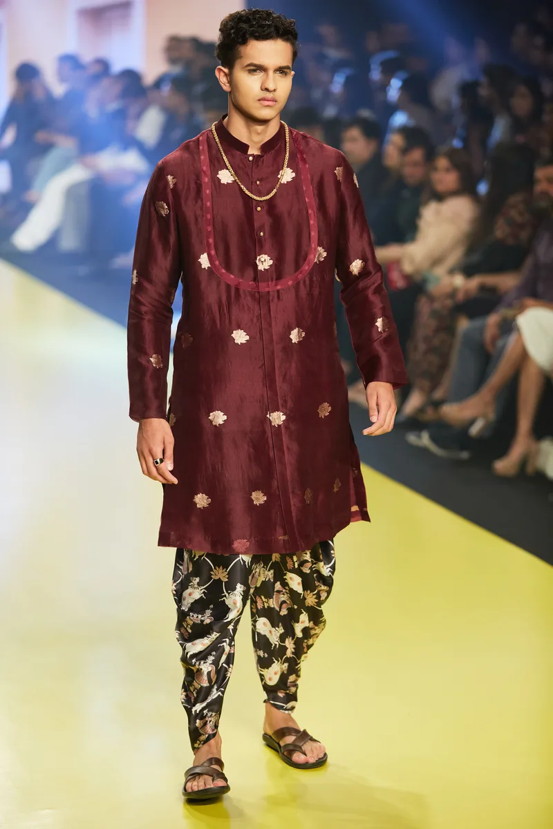 Model wearing a burgundy embroidered kurta with patterned trousers