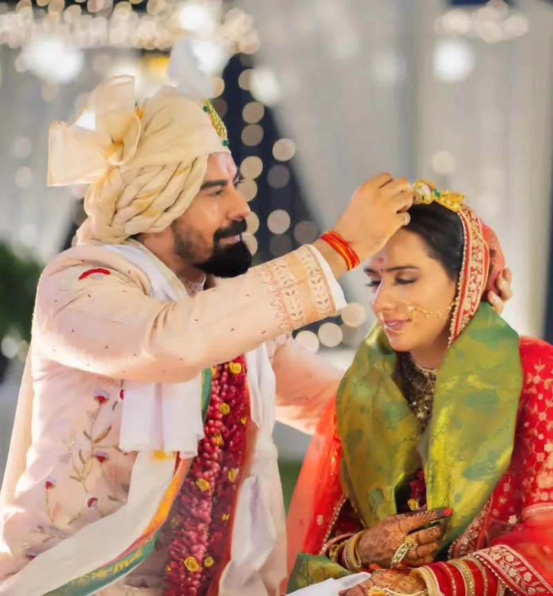 Groom in an ivory floral sherwani taking part in a wedding ceremony with the bride