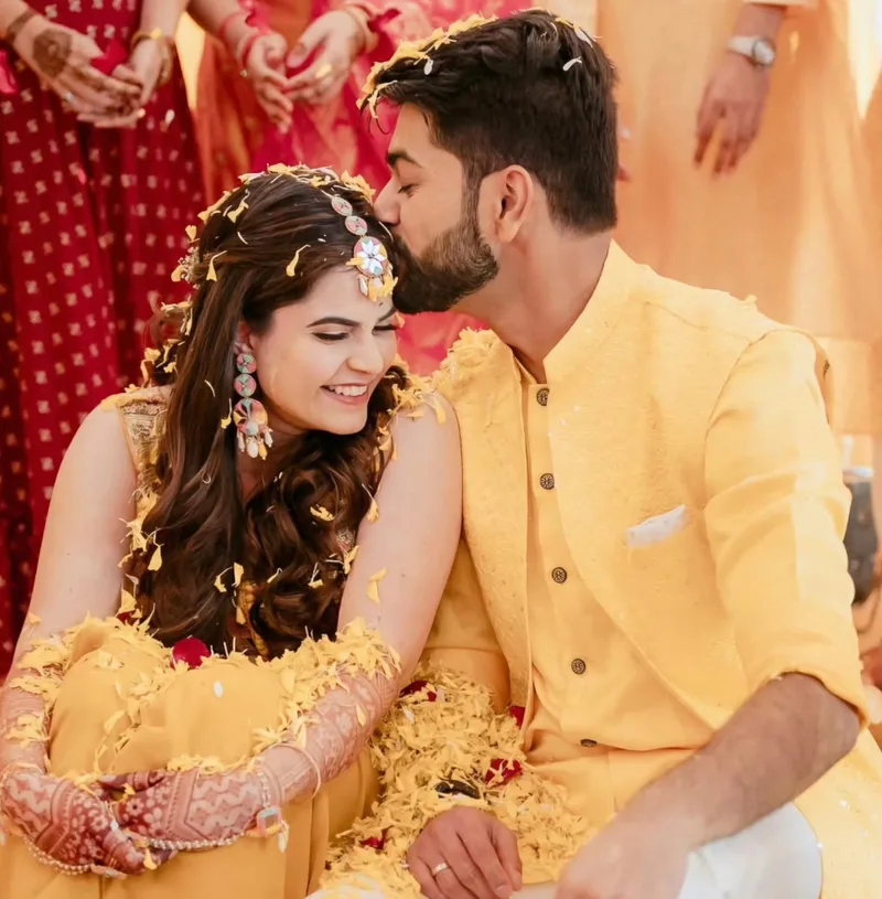 Couple wearing yellow outfits during their haldi celebration
