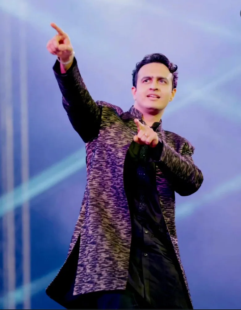 Man wearing a dark patterned jacket on stage