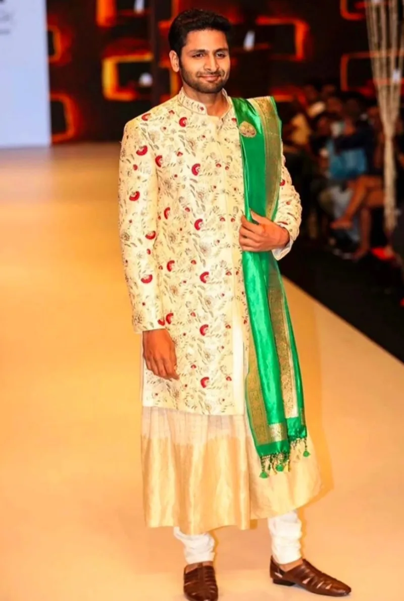 Man wearing an ivory floral kurta with a green stole