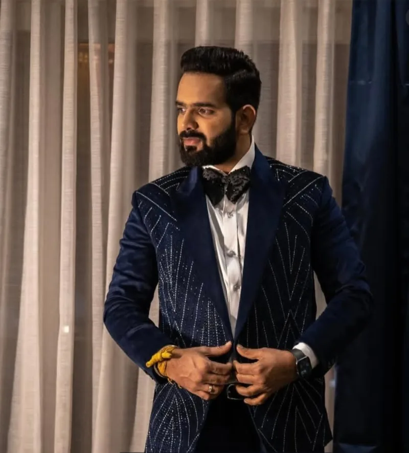 Man wearing a dark blue velvet tuxedo and bow tie